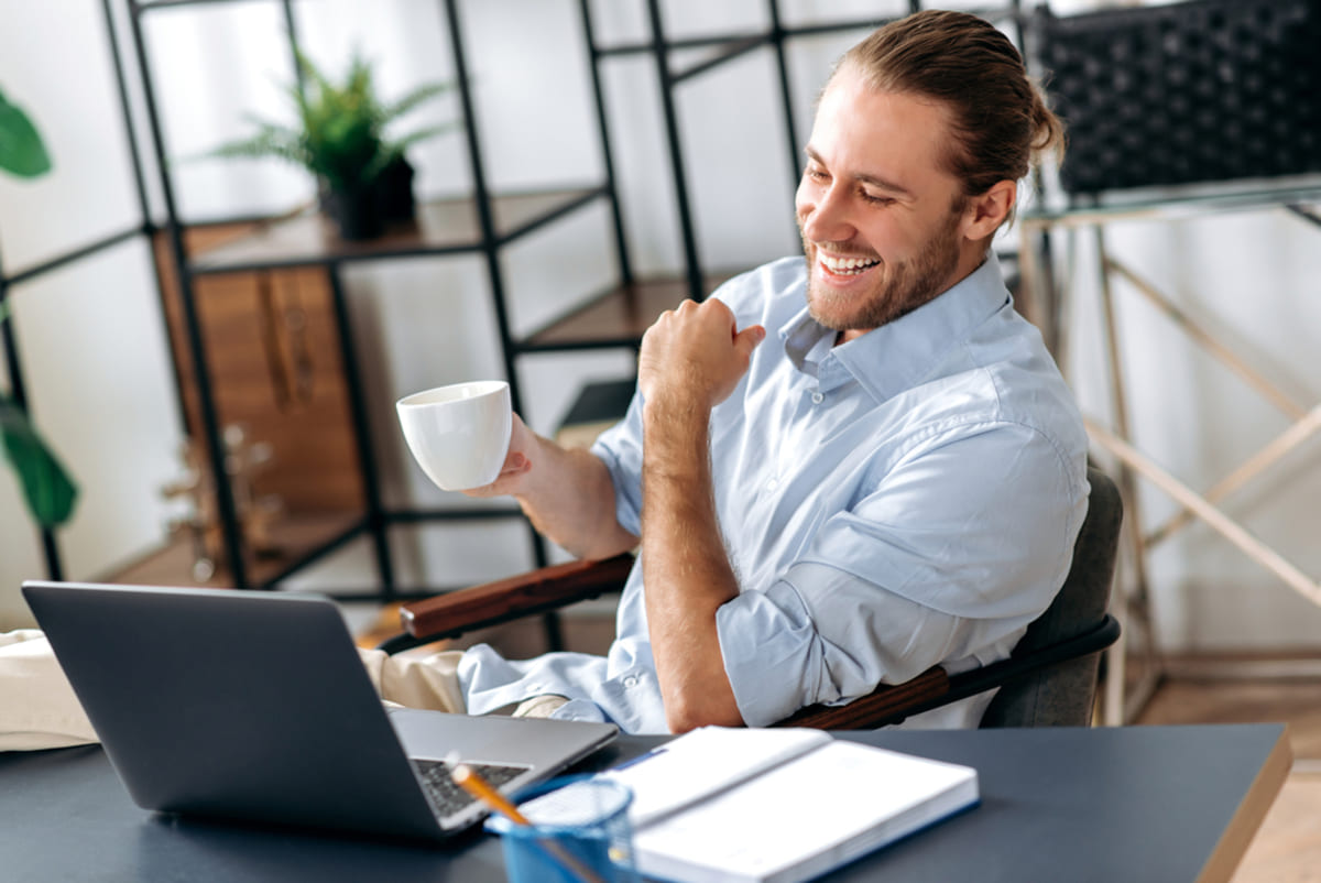 A happy and relaxed man sitting at his work desk