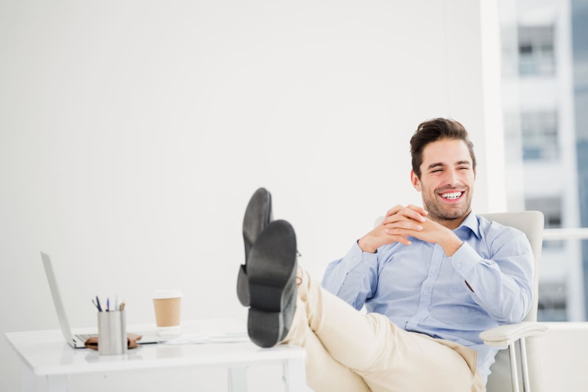A happy man with his feet up on his desk