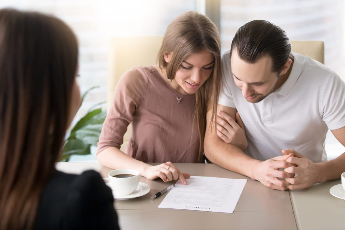 A property manager meets with tenants reading the lease, Hampton Roads real estate property management concept