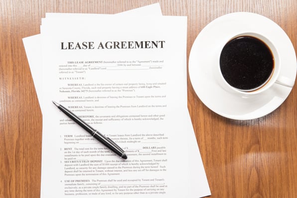 A rental lease agreement next to a coffee cup.