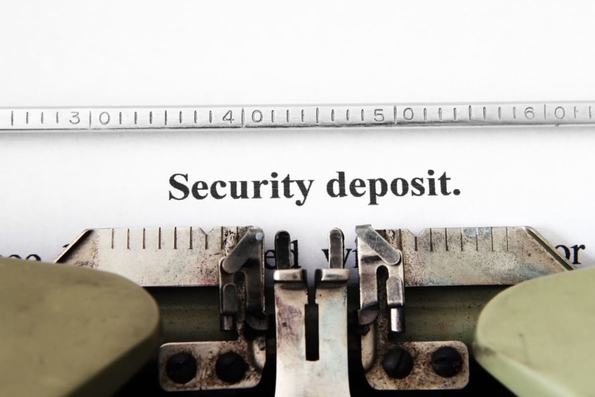 A typewriter typed the words security deposit, Rhino security deposit insurance alternative concept