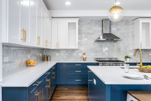 A white, blue, and gold kitchen highlighting the hardware and furnishings