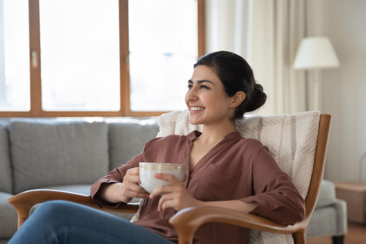 A woman lounging in a seat with a mug