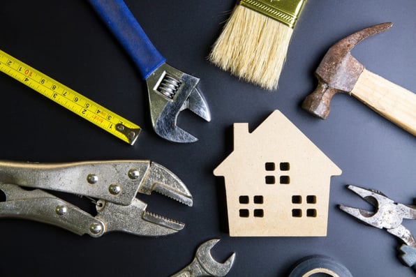 A wooden house with maintenance tools around it.