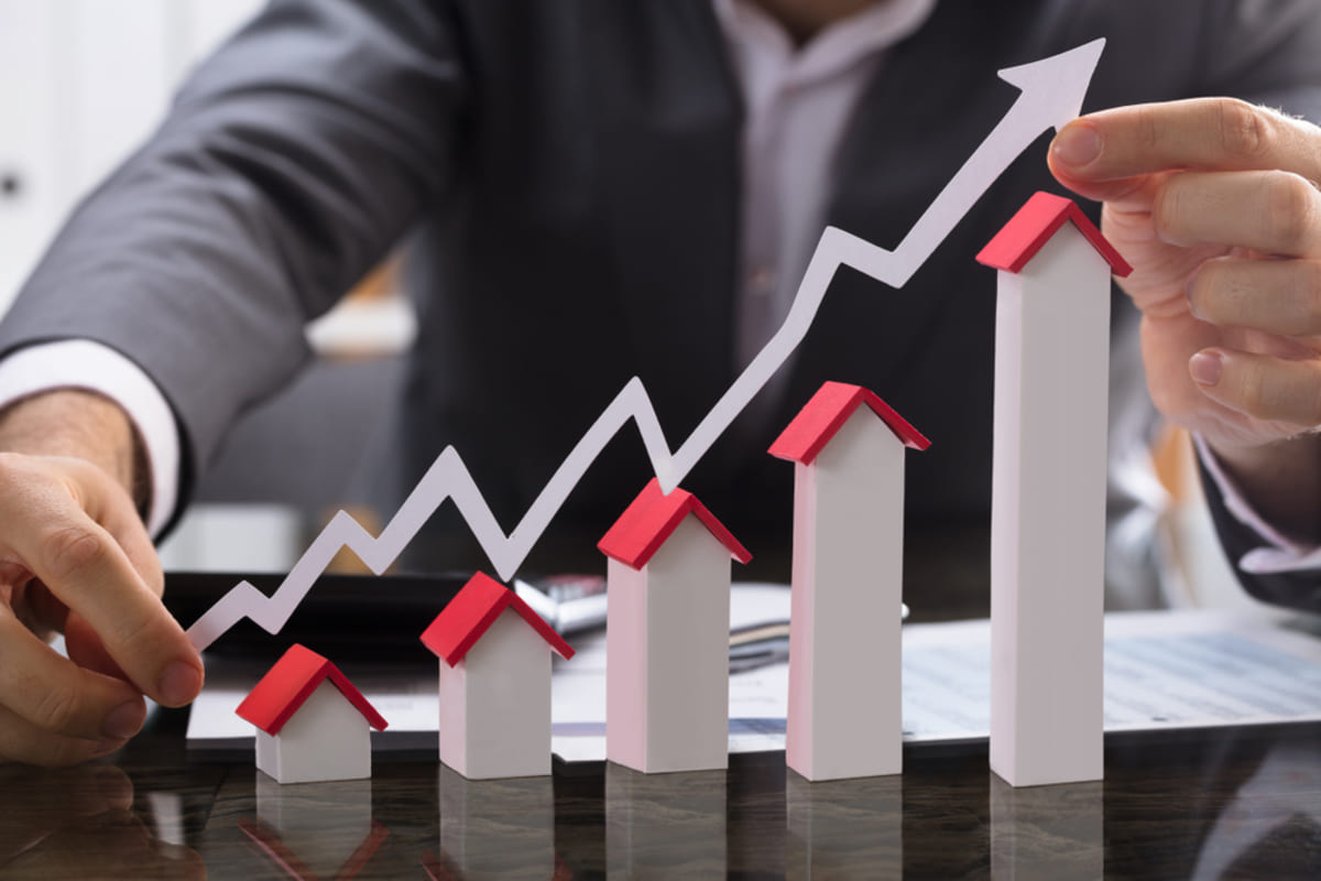 An arrow showing growth as model houses get taller