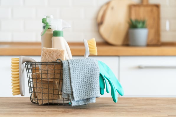 Basket with cleaning supplies on a counter, ROI boosting tips from rental management companies