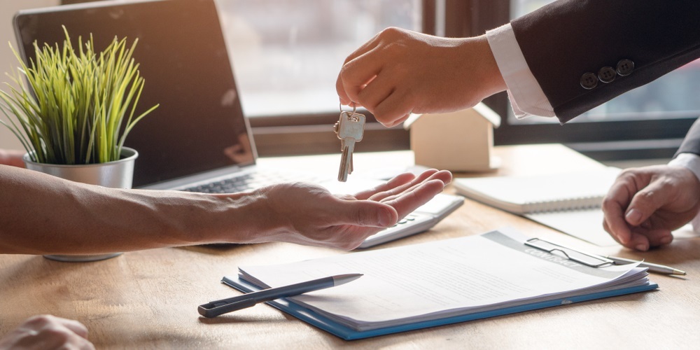 Close-up of hands receiving house keys, Osprey Property Management concept