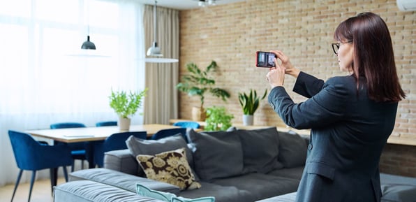 Property manager photographing rental property living room