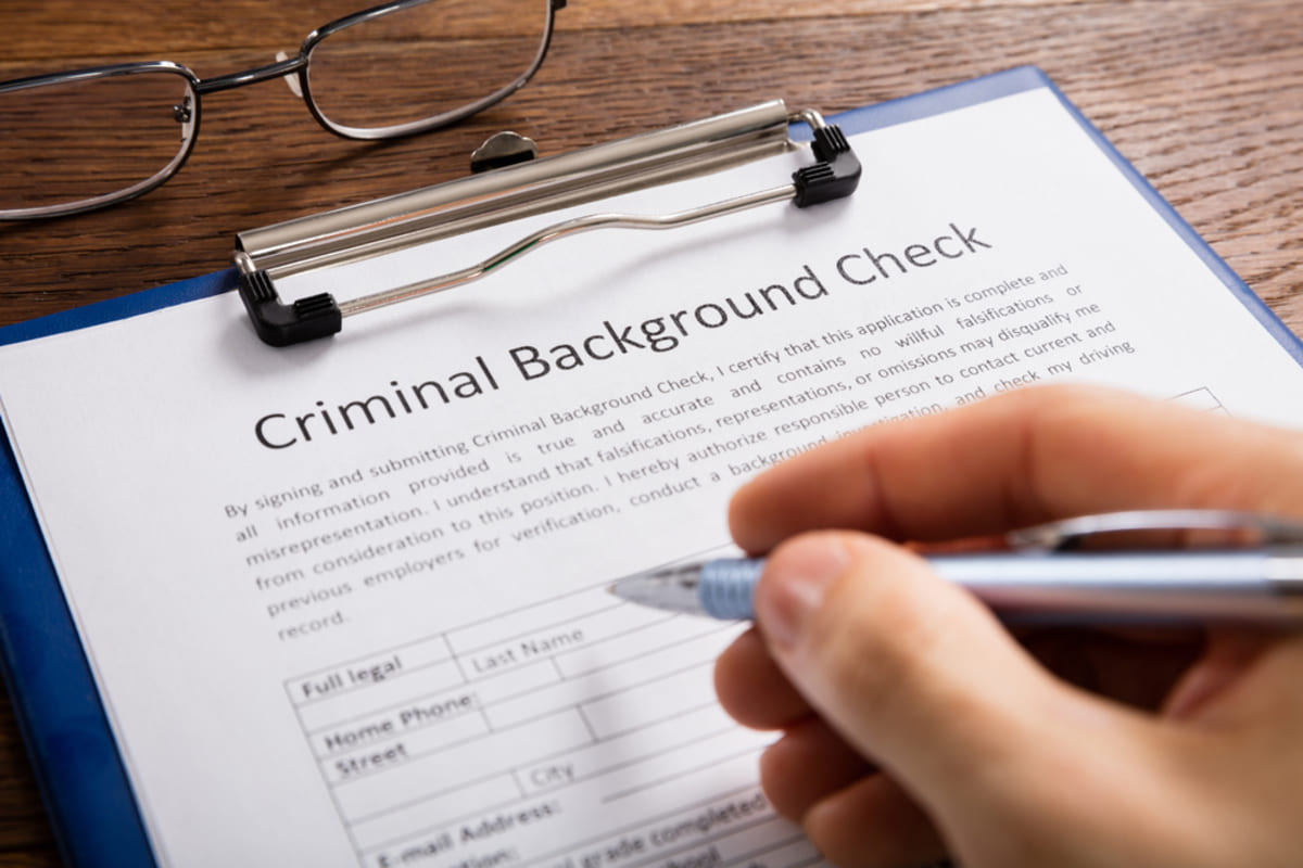 Someone filling out a document labeled criminal background check