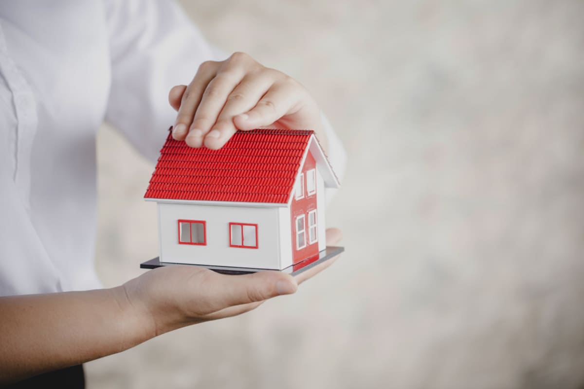 Someone holding a model home in their hands