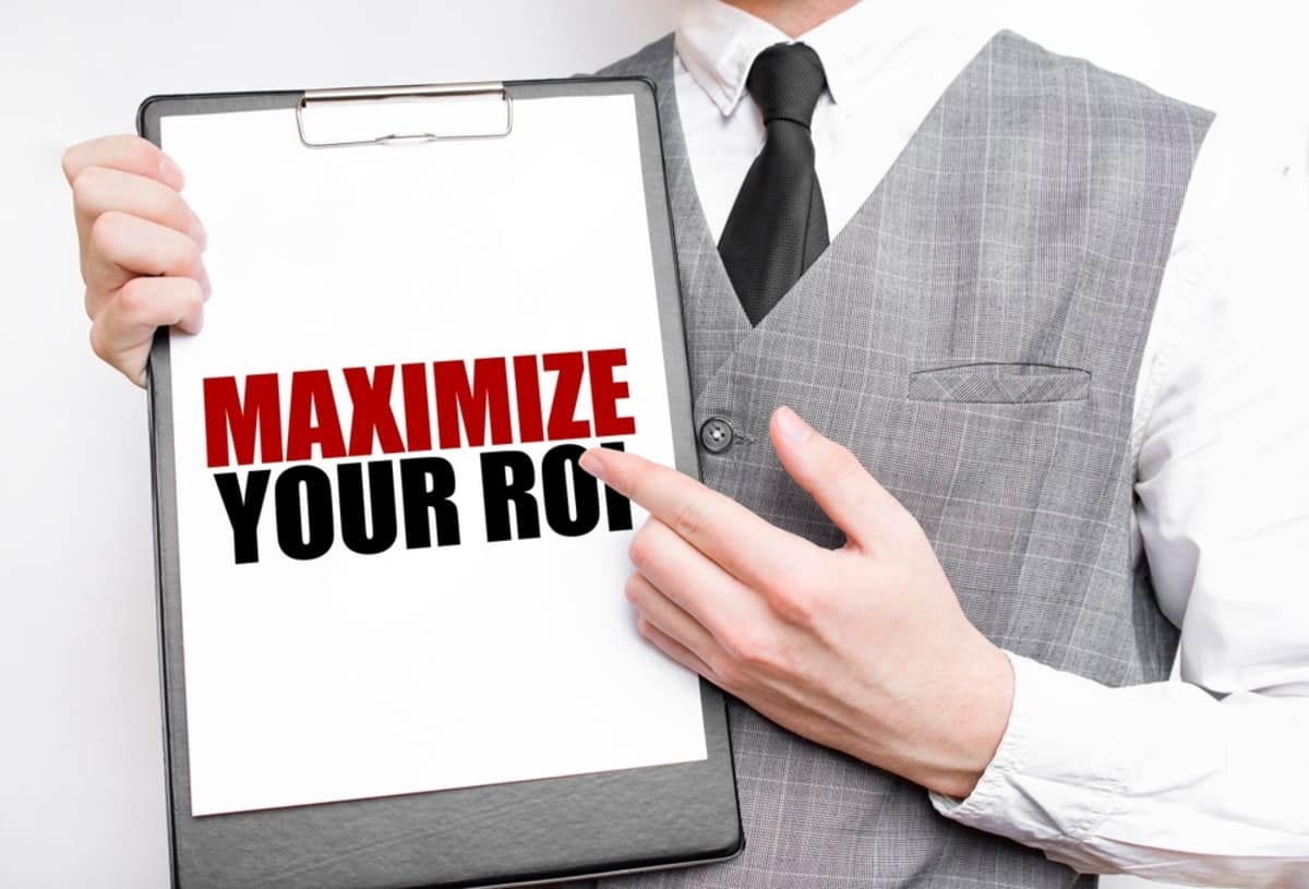 Someone holding a tablet that says maximize ROI