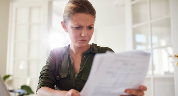 Female landlord looks stressed while reviewing rental property contract