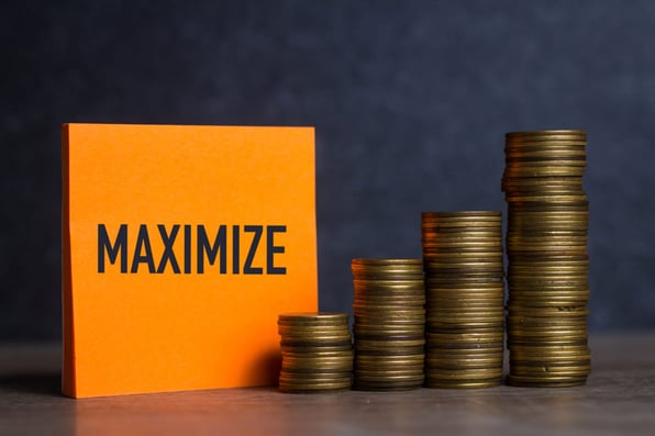 The word maximize behind stacked coins