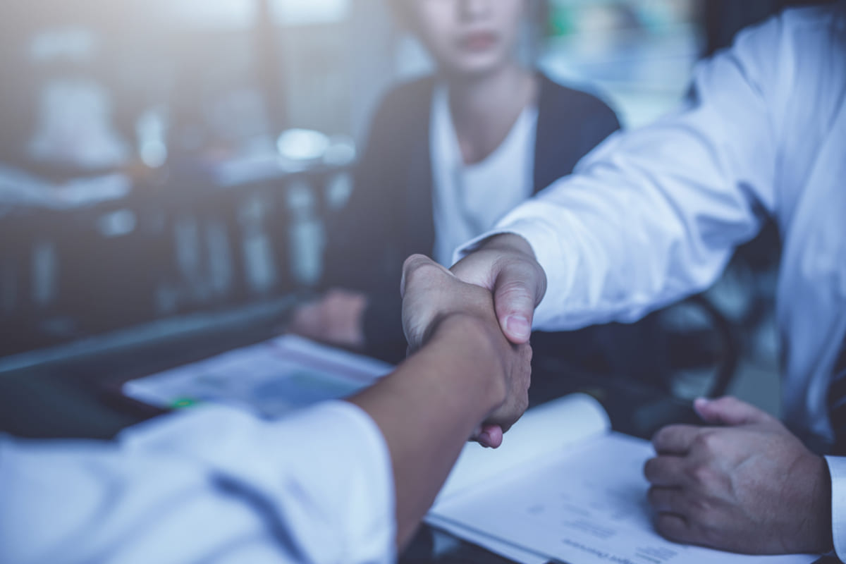 Two people shaking hands in a business setting