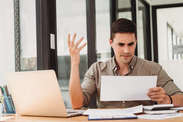 Frustrated property owner reviewing rental property financial statements