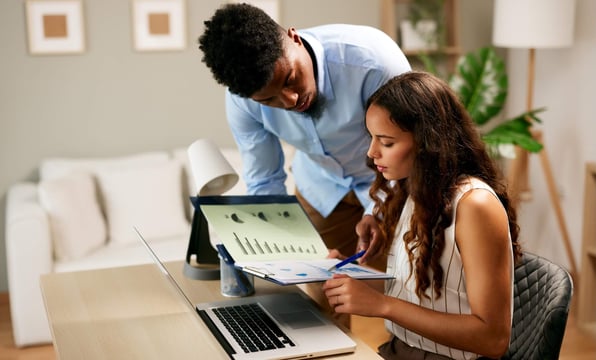 Male and female property owners review property management costs in contract