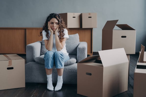 Evicted female tenant takes a break from packing up rental house