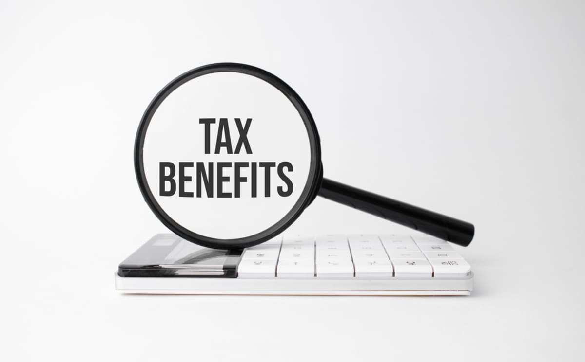 tax benefits with a magnifying glass and a calculator