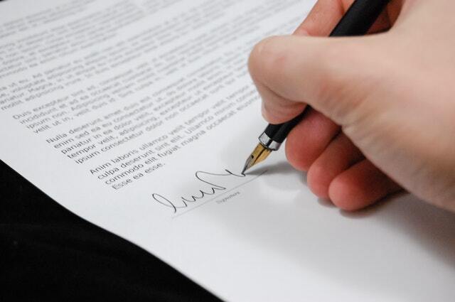 Close-up of hand signing a document, lease management with property management Hampton Roads offers concept. 