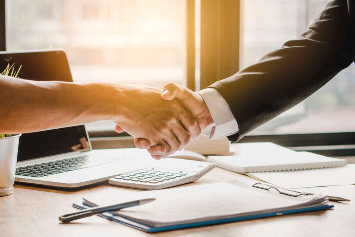A handshake shows the partnership and success when real estate investing with a property manager