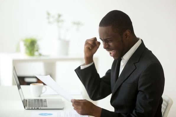 Excited african-american businessman holding letter with unexpected good news