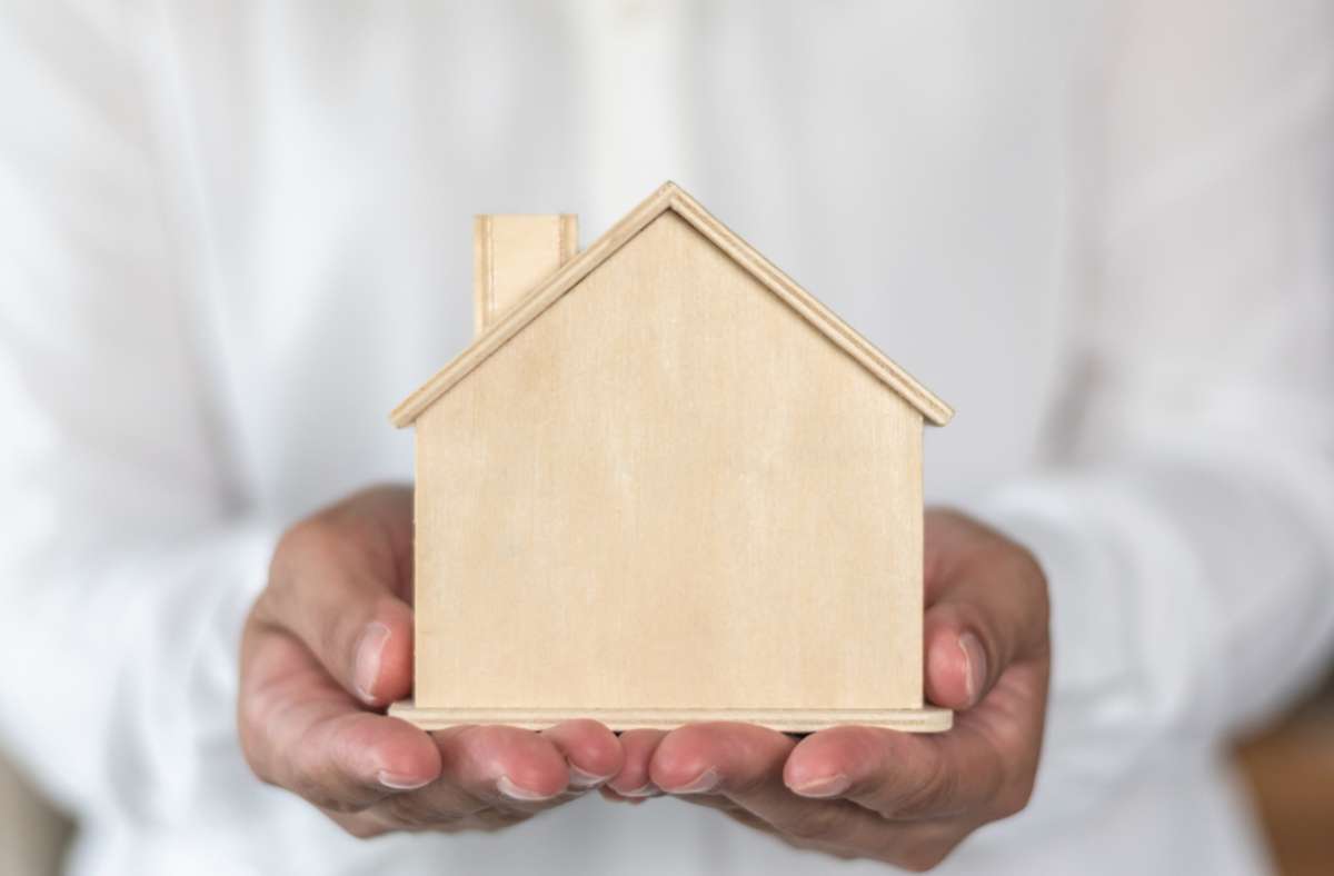 Hands holding a house model, Virginia Beach home rental companies concept