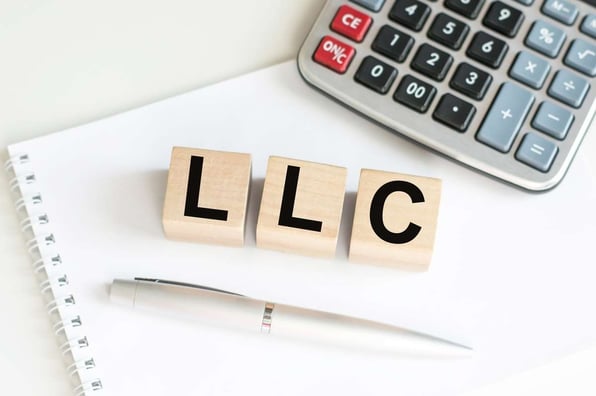 LLC in wooden block letters, entity structures for real estate concept