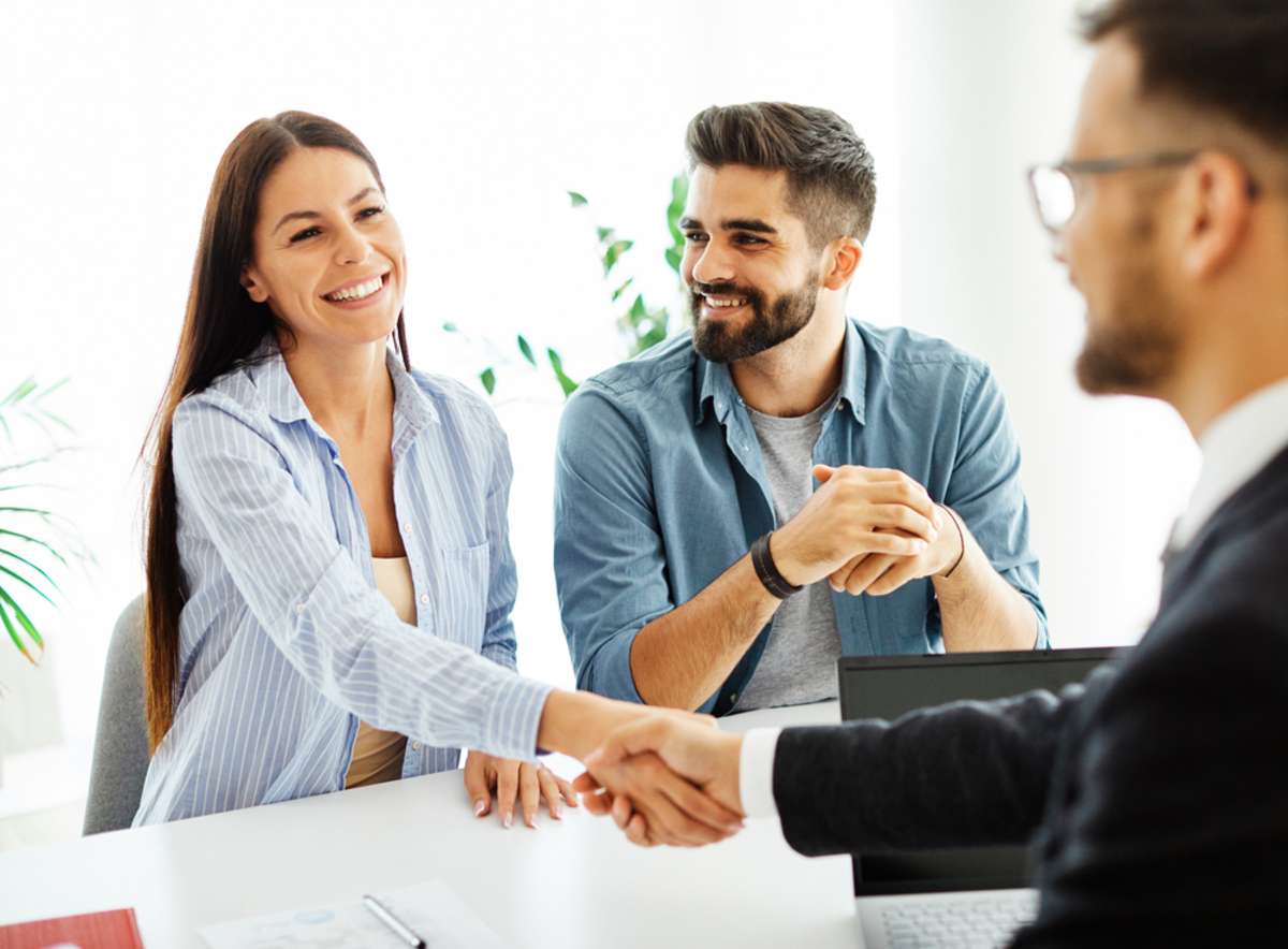 A property manager shaking hands with a couple, property management Suffolk concept. 