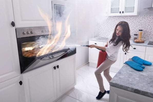 A woman battles an oven fire, emergency maintenance concept. 
