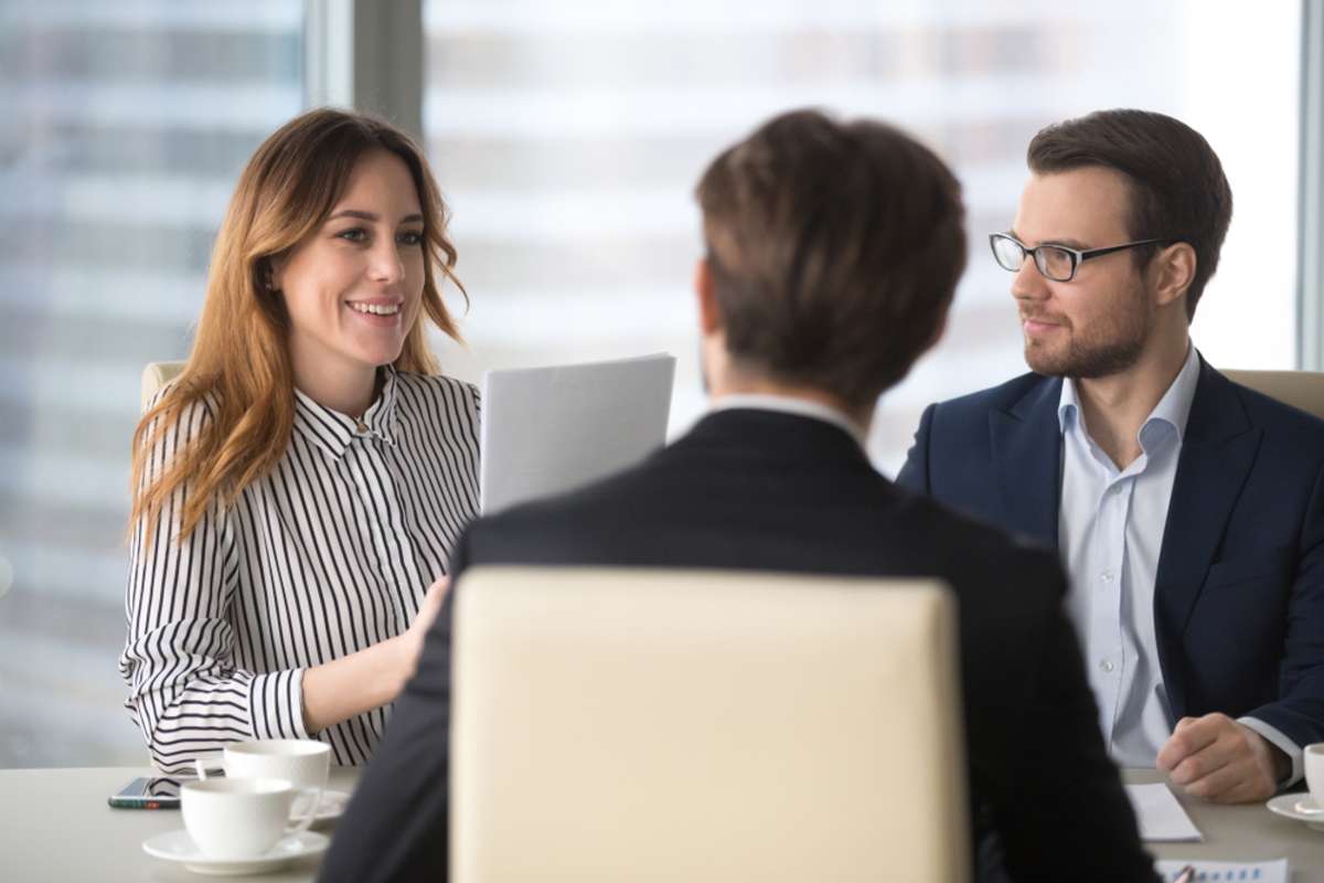 Young broker businesswoman talking to business partners