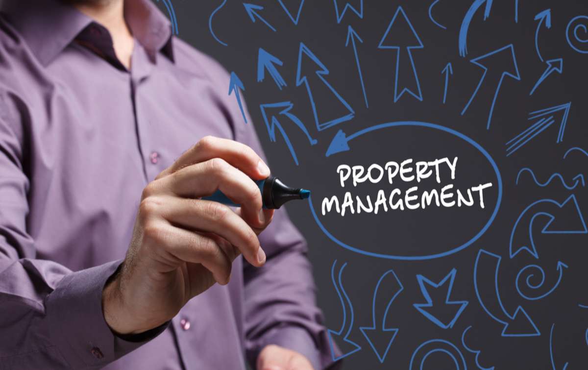 Young businessman writing "property management," finding property management in Virginia concept.