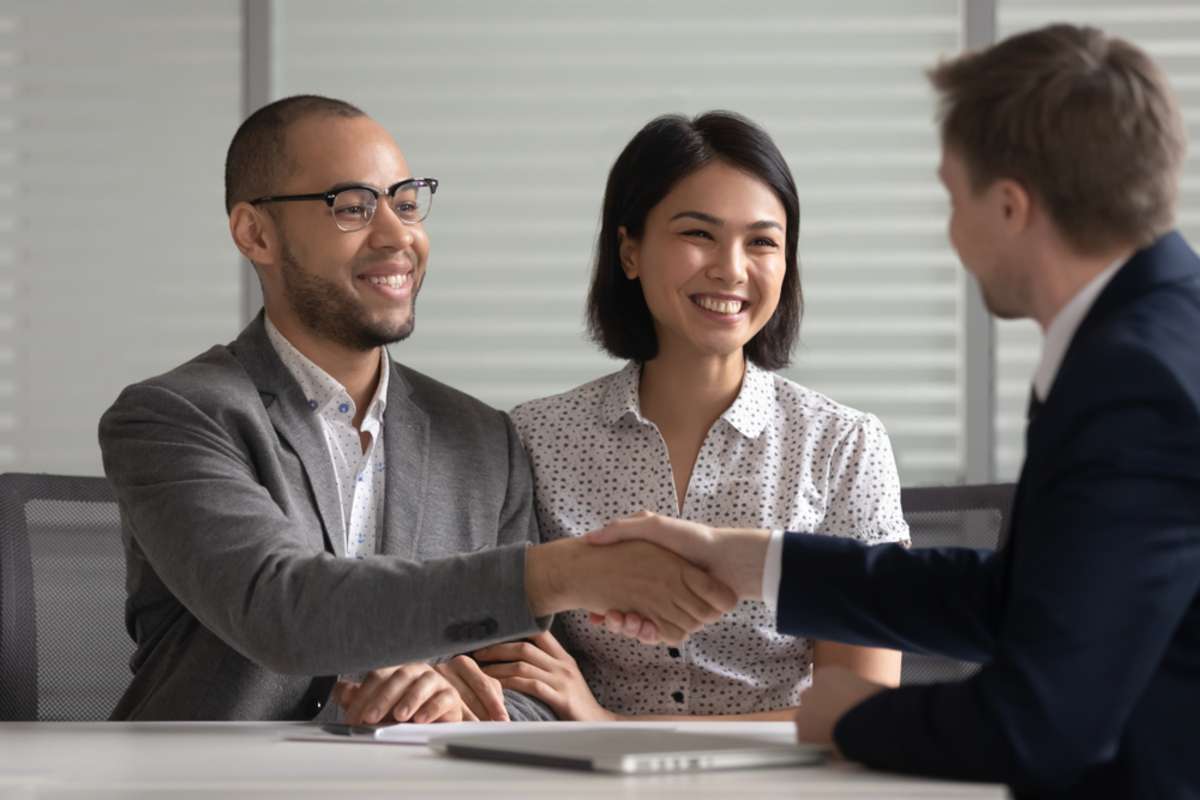 Young couple shakes hand with woman, Norfolk property management concept