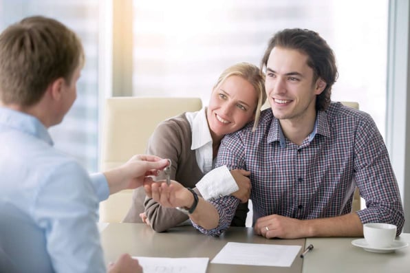 A couple getting a key for a rental home, being a landlord concept. 