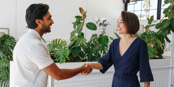 Businessman and businesswoman shaking hands in office
