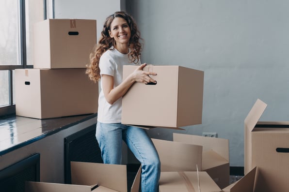 Female tenant moving boxes into new rental property