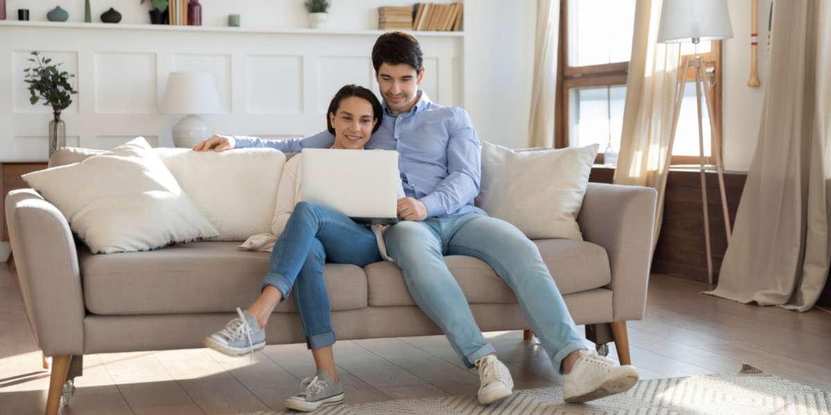 Young couple in love having date indoors, millennial married male and female owners, tenants or renters of new modern apartment resting on sofa